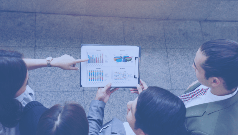 Business professionals analyzing a chart on a tablet, focusing on optimizing cloud spending with hybrid architecture and usage analytics.